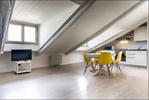 ein Wohnzimmer mit einem Tisch und gelben Stühlen in der Unterkunft Cibrario 34 in Turin