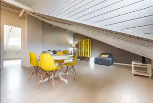 ein Esszimmer mit einem Tisch und gelben Stühlen in der Unterkunft Cibrario 34 in Turin
