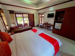 a bedroom with a large bed and a living room at First Bungalow Beach Resort in Chaweng