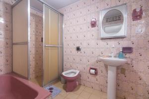 a bathroom with a pink tub and a toilet and a sink at Guest House Central in Florianópolis +18 photos