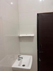 a white bathroom with a sink and a mirror at La Coral Residency in Pondicherry +56 photos