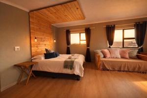 a bedroom with two beds and a couch in it at At the Indi in Struisbaai +1 photo