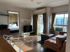 a living room with a couch and a television at Dcondo Creek Phuket 2BR in Kathu