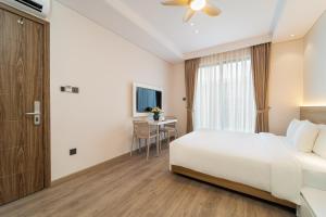 a hotel room with a bed and a table at Nina Sky Serviced Apartment in Ho Chi Minh City