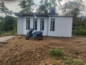 a scooter parked in front of a small house at Urisha homestay in Mawlynnong