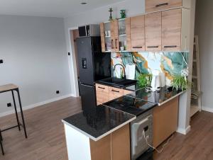 a kitchen with a counter and a black refrigerator at Jolanta's apartment in Hajnówka