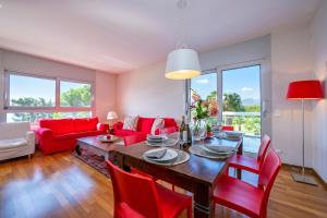 a living room with a table and red chairs at La Maison du Bonheur with Shared Pool & Sauna - Happy Rentals in Aldesago