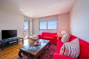 a living room with a red couch and a table at La Maison du Bonheur with Shared Pool & Sauna - Happy Rentals in Aldesago