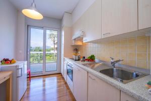 a kitchen with a sink and a large window at La Maison du Bonheur with Shared Pool & Sauna - Happy Rentals in Aldesago