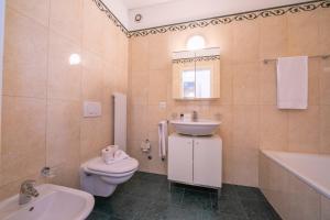 a bathroom with a sink and a toilet and a sink at La Maison du Bonheur with Shared Pool & Sauna - Happy Rentals in Aldesago +24 photos