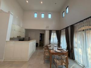 a kitchen with a table and chairs in a room at Estella Pool Villas Pattaya Formerly Chivani Pattaya in Na Jomtien