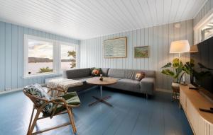 a living room with a couch and a table at Nice Home In Risør With House Sea View in Risør