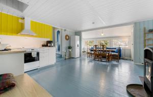 a kitchen and dining room with yellow and blue walls at Nice Home In Risør With House Sea View in Risør