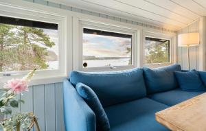 a blue couch in a room with two windows at Nice Home In Risør With House Sea View in Risør +22 photos