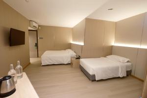 a hotel room with two beds and a television at Hotel Ming Star in Kuala Terengganu