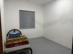 a room with a bed with a window and a pillow at DF Homestay in Kangar