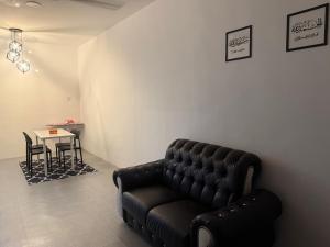 a black leather couch in a room with a table at DF Homestay in Kangar