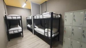 a room with two bunk beds in a room at Yellow Monkey Hostel Uluwatu in Uluwatu