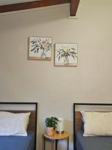 two beds in a room with two pictures on the wall at 12 apostles cottages in Princetown