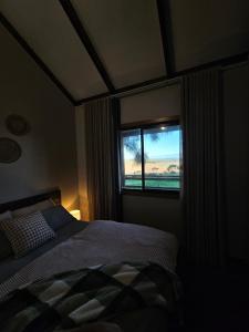 a bedroom with a bed and a window at 12 apostles cottages in Princetown