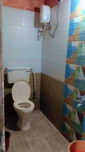 a bathroom with a toilet and a colorful wall at Sky cottage in Jāmb +38 photos