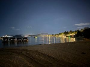 a beach with a dock in the water at night at Spectacular Sunrise and Mountain Views in Mae Nam +3 photos