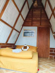 a bedroom with a yellow bed in a attic at VANY Glamping in Pasuruan