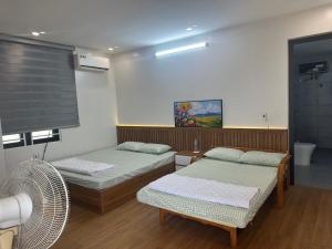a room with two beds and a fan at Bong Mai Thai Hoa Hotel in Làng Dương