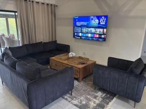 a living room with two couches and a tv at 127 Clarens Golf Villa in Clarens +67 photos