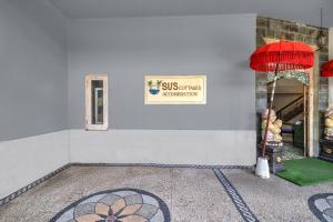 a white building with a sign on the side of it at Townhouse Oak Su's Cottage Near Legian Beach in Legian