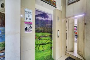a hallway with a window with a painting on the wall at Townhouse Oak Su's Cottage Near Legian Beach in Legian