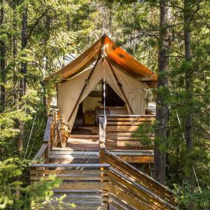 a tent on a wooden deck in the woods at Namdong Waterfall & Eco Resort in Luang Prabang