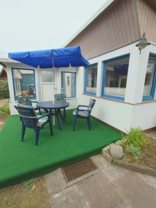 a patio with a table and chairs and an umbrella at Haus Katharina in Loissin