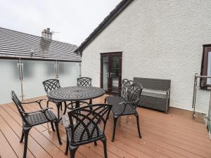 a patio with a table and chairs on a deck at Striding Home in Ambleside