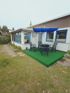 a house with a table and chairs on a lawn at Haus Katharina in Loissin