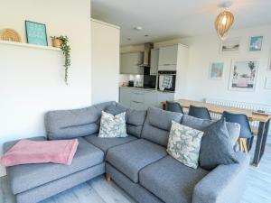 a living room with a couch and a kitchen at Dune Retreat in Rhosneigr