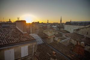 - une vue sur les toits d'une ville au coucher du soleil dans l'établissement La Loge du 12, à Bordeaux