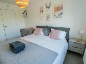a bedroom with a bed with a suitcase on it at Dune Retreat in Rhosneigr
