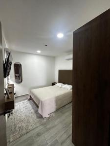 a bedroom with a bed and a flat screen tv at Depto Vista Cañón del Sumidero in Cerro Hueco