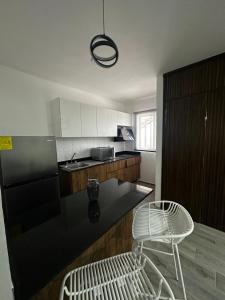 a kitchen with a black counter and a white chair at Depto Vista Cañón del Sumidero in Cerro Hueco
