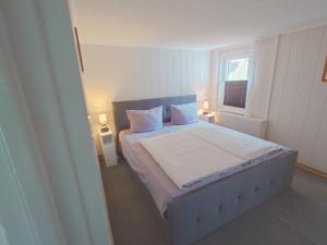 a bedroom with a bed with two pillows and a window at Haus Katharina in Loissin