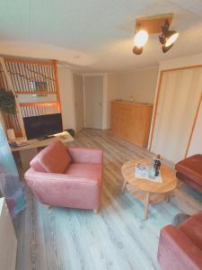 a living room with a pink couch and a table at Haus Katharina in Loissin