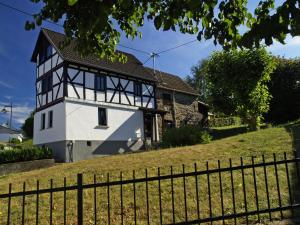 a black and white house on a hill with a fence at Ferienhaus FachWerk in Holler