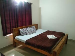 a bedroom with a bed and a window at Brookfield estate villa 2bhk in Madikeri