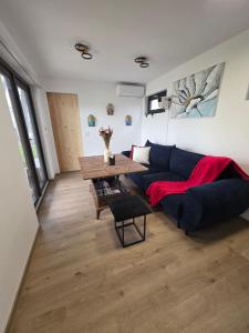 a living room with a blue couch and a table at Badash Tiny Village - Tiny Houses with Heated Pool & BBQ in Polovragi