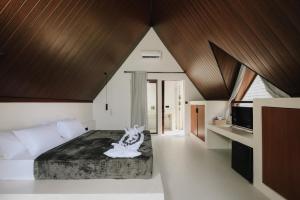 a bedroom with a large bed with wooden ceilings at Limbo Lux Bungalows in Kuta Lombok