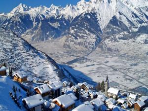 a village covered in snow with mountains in the background at Sunny chalet in Veysonnaz for 10 guests in Veysonnaz