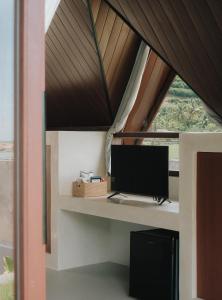 a computer on a desk in a room with a window at Limbo Lux Bungalows in Kuta Lombok