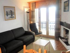 a living room with a couch and a fireplace at Cozy apartment for groups in Veysonnaz