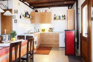 a kitchen with a red refrigerator and a table at Ca Brunella 2 Lake Maggiore View Terrace for Four - Happy Rentals in Riazzino